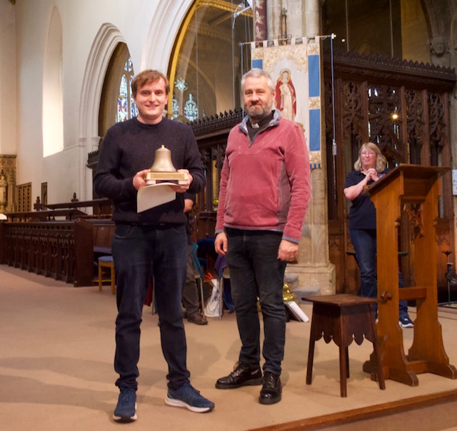 Julian Howes, conductor of the winning St Stephen's team, receiving the Higby Trophy from the vicar, Reverend Tobie Osmond.